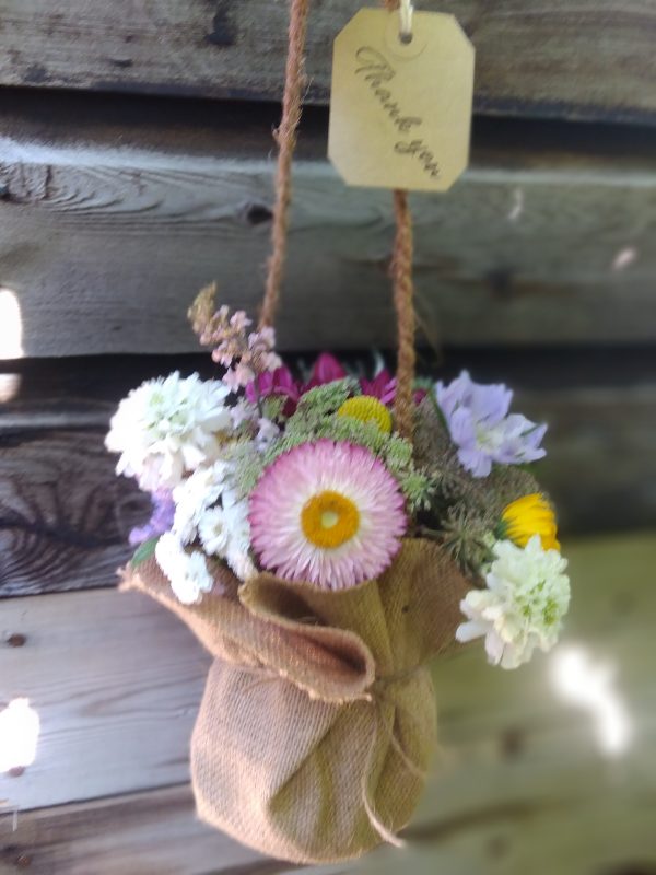 A hessian covered jar with meadow style flowers for a Teachers end of term gift. Posie of flowers
