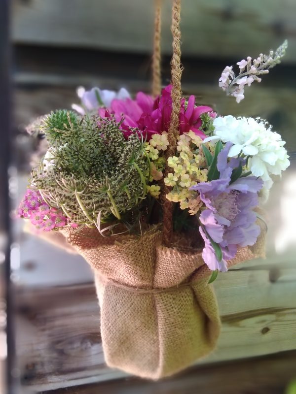 Posie of flowers in jam jar with hessian wrap and handle